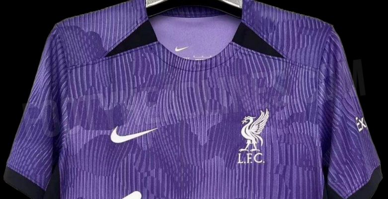 Cổ áo có hai hình tam giác màu tím đậm đối xứng, logo phải Swoosh của Nike và ngực trái là logo Liverpool màu trắng